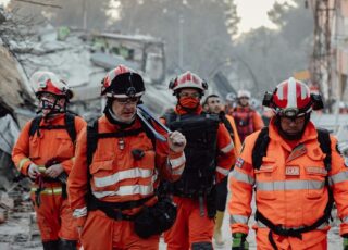 A team from International Search and Rescue (ISAR) walking through a demolished town. This image is being used in article that describes CTH's support for the victims of the earthquake in Myanmar.